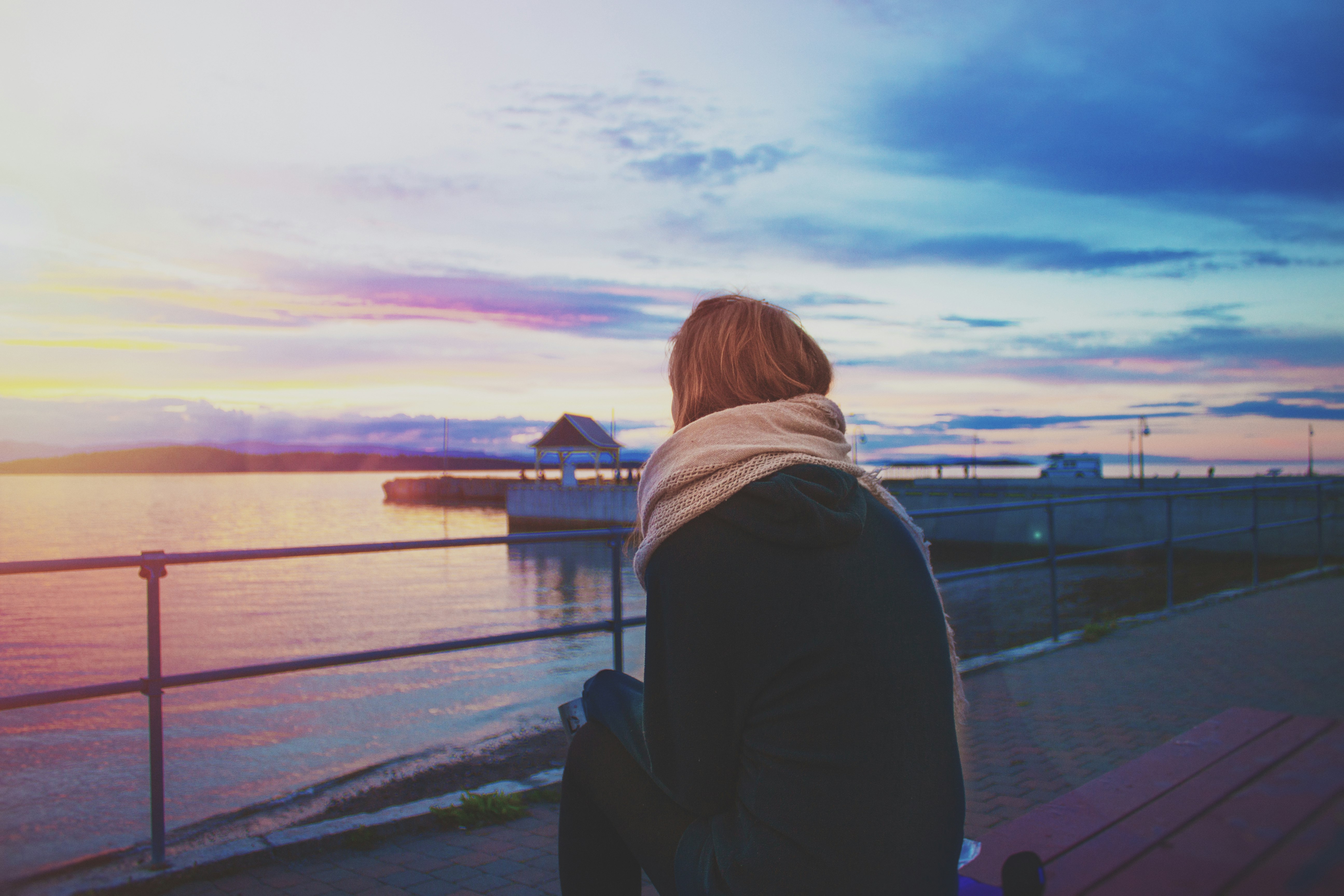 unknown person sitting on brown bench outdoors